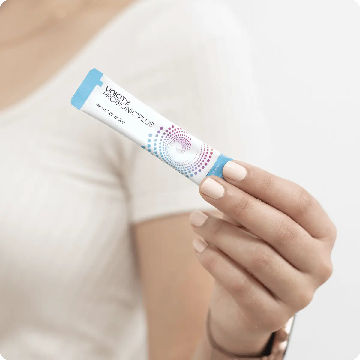 Woman holding stick pack of ProBionic Plus by Unicity