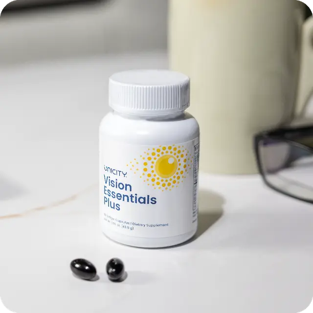 Envase de Vision Essentials Plus junto a las cápsulas blandas