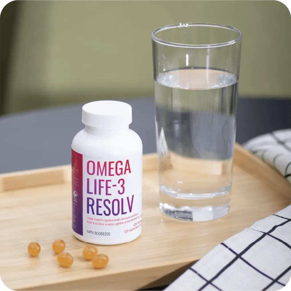 OmegaLife-3 Resolv à côté des capsules molles et d'un verre d'eau