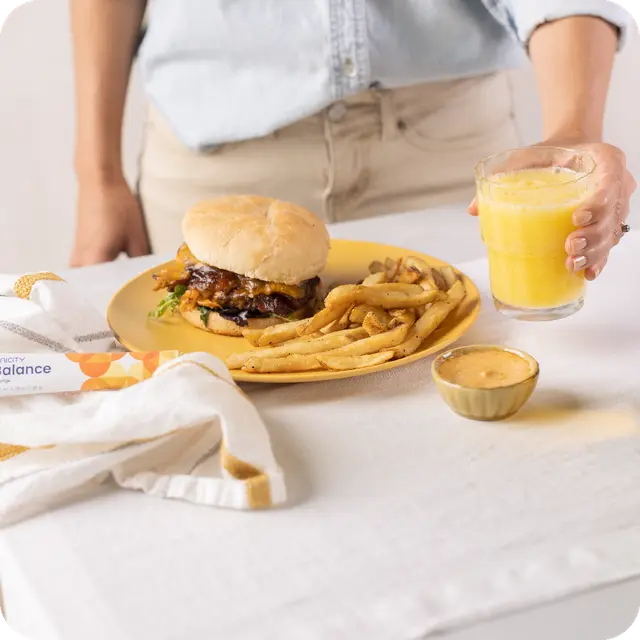 Person holding glass of Unicity Balance next to food