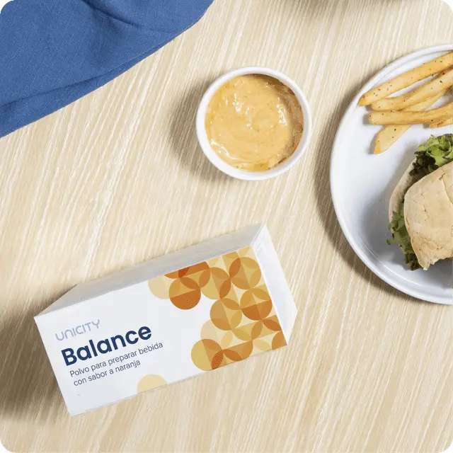 Caja de Unicity Balance junto a un plato de comida