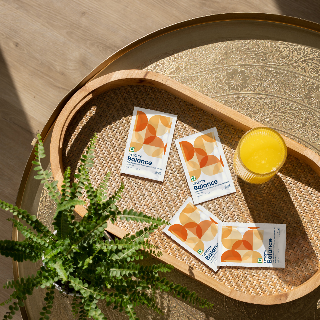 Glass of Unicity Balance next to sachets