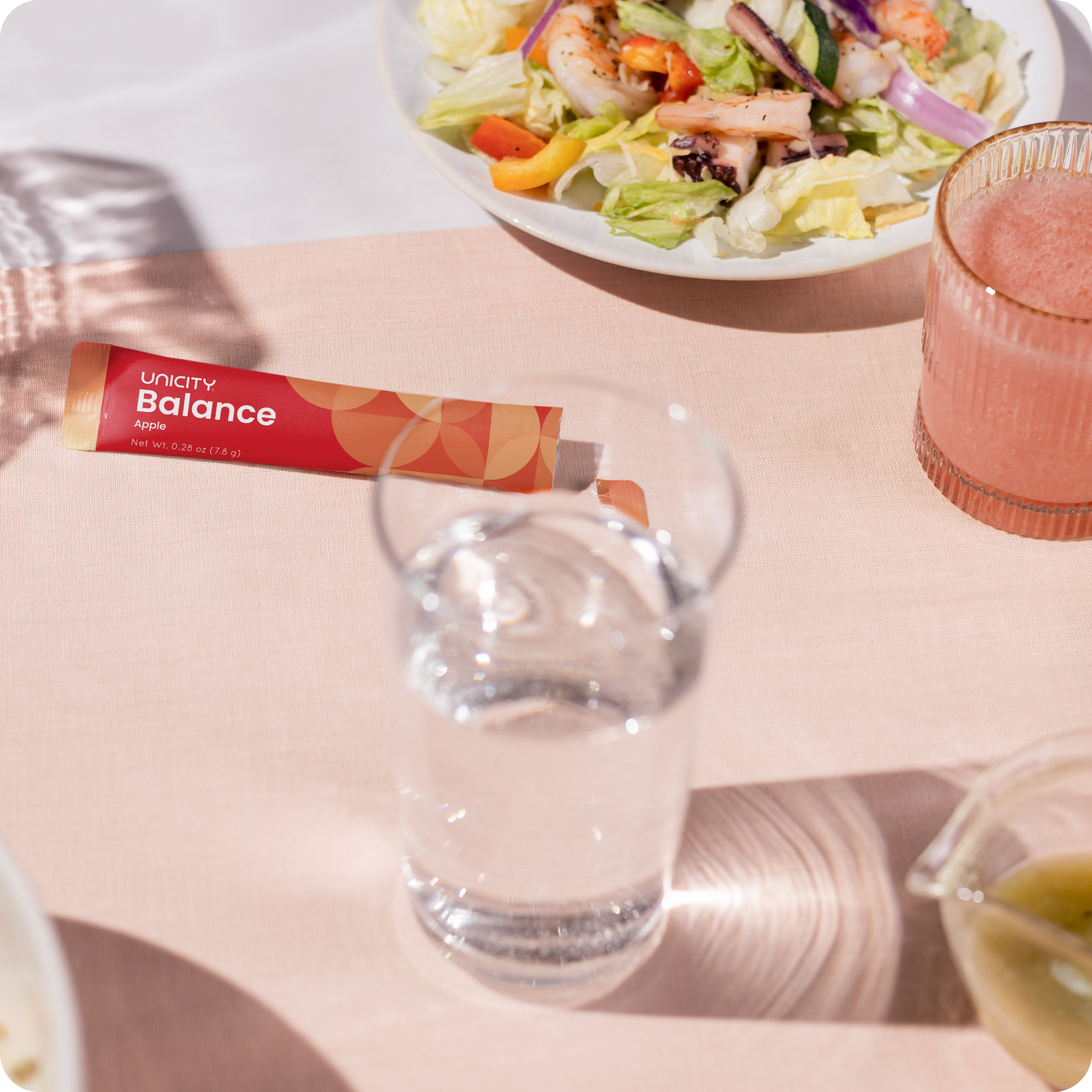 Glass of Unicity Balance next to stick pack