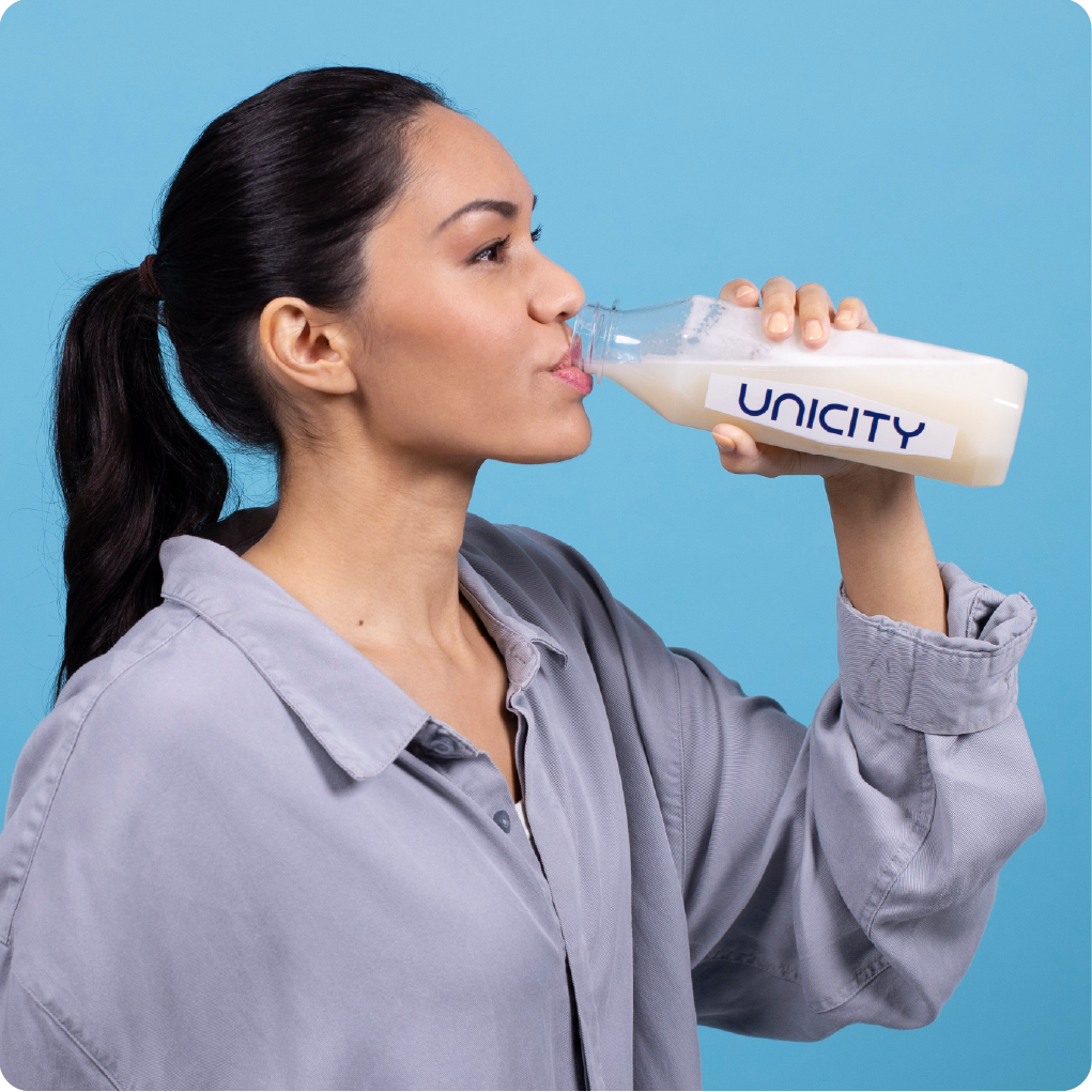 Chica bebiendo LC PRO de una botella Unicity Diamond